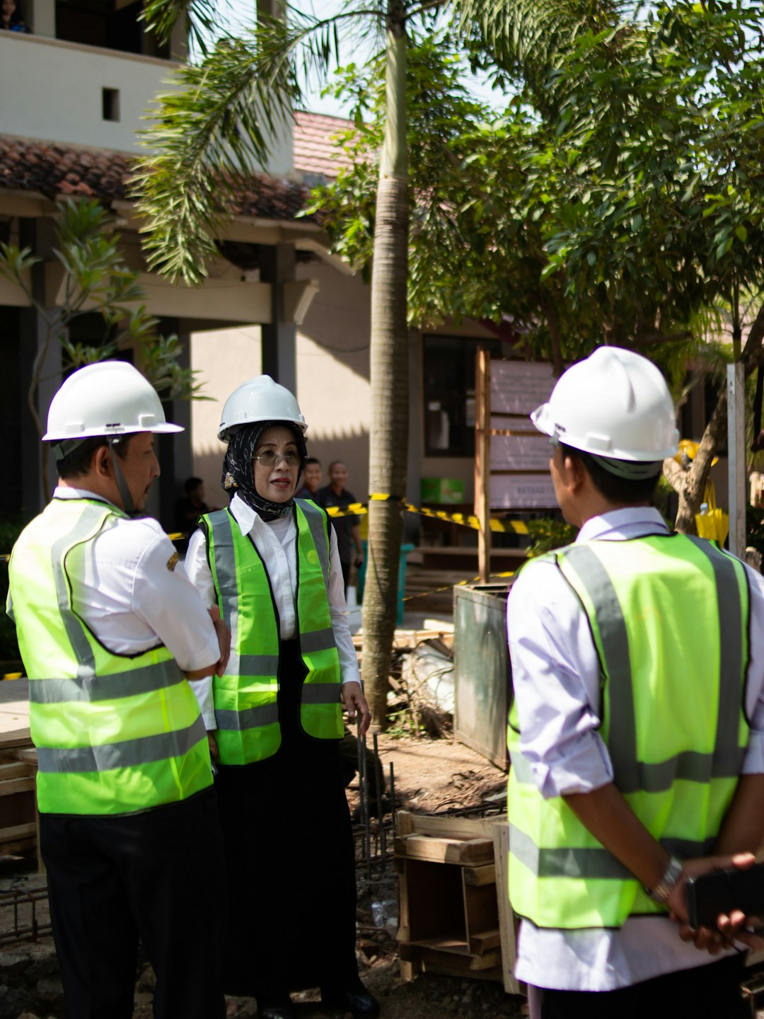 Industrial workforce team in safety gear discussing work at a project site